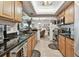 Well-lit kitchen featuring stone countertops, stainless steel appliances, and views into the dining area at 36750 Us 19 N # 22212, Palm Harbor, FL 34684