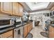 Modern kitchen with sleek stainless steel appliances and natural wood cabinetry, overlooking the dining area at 36750 Us 19 N # 22212, Palm Harbor, FL 34684