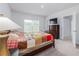 Cozy bedroom featuring a large window, comfortable bed, and a chest of drawers with television at 3686 Zephyr Preserve Pl, Zephyrhills, FL 33541