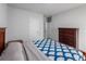 Comfortable bedroom with a blue patterned quilt, wooden dresser, and neutral walls at 3686 Zephyr Preserve Pl, Zephyrhills, FL 33541