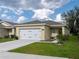 Charming single-story home with a two-car garage, manicured lawn, and inviting curb appeal under a blue sky at 3686 Zephyr Preserve Pl, Zephyrhills, FL 33541