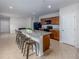 Open kitchen featuring a granite island with barstool seating, stainless steel appliances, and wood cabinetry at 3686 Zephyr Preserve Pl, Zephyrhills, FL 33541