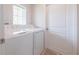 This laundry room has a modern washer and dryer, a window for natural light, and a tile floor for easy cleaning at 3686 Zephyr Preserve Pl, Zephyrhills, FL 33541