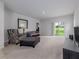 Spacious living room with a sliding door, neutral carpet, and modern furniture at 3686 Zephyr Preserve Pl, Zephyrhills, FL 33541