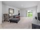Bright living room with a sliding glass door to the backyard, plush carpeting, and stylish decor at 3686 Zephyr Preserve Pl, Zephyrhills, FL 33541