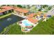 Aerial view showcasing the apartment complex with a pool and surrounding lush greenery and pond with fountain at 4302 Bayside Village Dr # 102, Tampa, FL 33615