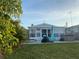 Outdoor patio area with a hot tub, seating, grill, and views of the lush backyard and sunroom at 4551 Floramar Ter, New Port Richey, FL 34652