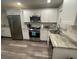 Well-lit kitchen featuring stainless steel appliances and white cabinetry at 4551 Floramar Ter, New Port Richey, FL 34652