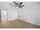 Spacious bedroom featuring wood floors, ceiling fan, and access to other rooms at 5482 Salem Square N Dr, Palm Harbor, FL 34685