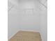 Walk-in closet includes wood flooring and shelving for clothing and storage at 5482 Salem Square N Dr, Palm Harbor, FL 34685