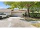 Single story home featuring a two-car garage, mature landscaping, and a concrete driveway and walkway at 5482 Salem Square N Dr, Palm Harbor, FL 34685