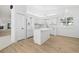 Bright kitchen featuring wood flooring, an island, modern cabinets, and ample counter space at 5482 Salem Square N Dr, Palm Harbor, FL 34685