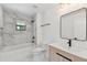 Bathroom with marble tiles, new light fixtures, tub, and a modern vanity at 6315 S Richard Ave, Tampa, FL 33616