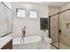 Sleek bathroom boasts a freestanding tub, modern fixtures, and a glass-enclosed shower, providing a luxurious retreat at 6315 S Richard Ave, Tampa, FL 33616