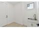 Clean laundry room featuring utility sink and door at 6315 S Richard Ave, Tampa, FL 33616
