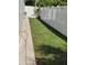 A long, narrow backyard space is grassed and enclosed with a tall, white privacy fence and a small tree at 6690 54Th N Ave, St Petersburg, FL 33709
