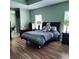 Bedroom features wood-look flooring, an inviting bed with accent pillow, and ensuite bathroom access at 6690 54Th N Ave, St Petersburg, FL 33709