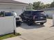 Driveway view shows an attached garage home with two parked cars in front on a sunny day at 6690 54Th N Ave, St Petersburg, FL 33709