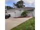 Charming single-story home featuring a two-car garage, complemented by lush landscaping and mature trees at 6690 54Th N Ave, St Petersburg, FL 33709