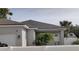 Modern house exterior with a white fence, gray roof, and neutral stucco siding at 6690 54Th N Ave, St Petersburg, FL 33709