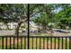 A balcony view overlooking a parking lot with mature trees and well maintained landscaping at 801 Russell Ln # 255, Brandon, FL 33510