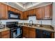 A kitchen featuring a black range, microwave, and dishwasher with granite countertops at 801 Russell Ln # 255, Brandon, FL 33510