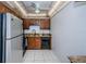 A fully equipped kitchen with stainless steel refrigerator and dark brown cabinetry at 801 Russell Ln # 255, Brandon, FL 33510