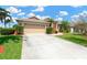 Well-maintained home showcases a spacious driveway and a manicured lawn under a bright, partly cloudy sky at 8902 30Th E St, Parrish, FL 34219