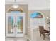 Grand foyer with decorative glass front doors and dining room with window shutters on the side at 8902 30Th E St, Parrish, FL 34219