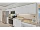 Well-maintained kitchen featuring granite countertops, stainless steel appliances, and white cabinetry at 8902 30Th E St, Parrish, FL 34219