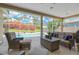 Comfortable screened patio with wicker furniture overlooks the beautiful pool and garden at 8902 30Th E St, Parrish, FL 34219