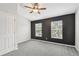 Bedroom featuring two windows, neutral carpeting, ceiling fan, and black accent wall at 10407 Westpark Preserve Blvd, Tampa, FL 33625