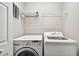 Laundry room with a side-by-side washer and dryer and wire shelving unit above at 10407 Westpark Preserve Blvd, Tampa, FL 33625