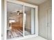 View from screened lanai of open floor plan, showing living room with wood floors, ceiling fan, and kitchen beyond at 10407 Westpark Preserve Blvd, Tampa, FL 33625