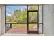 View from screened lanai out to lush lawn and mature trees, with door leading to the outside at 10407 Westpark Preserve Blvd, Tampa, FL 33625