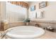 Relax in this garden tub with tile surround, window, and plantation blinds at 11534 Biddeford Pl, New Port Richey, FL 34654