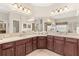 This bathroom features dual vanity, dark wood cabinets, and a window for natural light at 11534 Biddeford Pl, New Port Richey, FL 34654