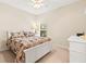 Bright bedroom with a white bed frame, floral bedding, ceiling fan, and a white dresser at 11534 Biddeford Pl, New Port Richey, FL 34654