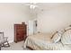 Well-lit bedroom featuring neutral tones, ceiling fan, dresser, and a comfortable rocking chair at 11534 Biddeford Pl, New Port Richey, FL 34654