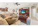 Open living room with large sectional, dark wood entertainment center, and coffered ceiling at 11534 Biddeford Pl, New Port Richey, FL 34654