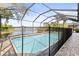 A screened pool has a safety fence, a paved patio, and a view of the water at 11534 Biddeford Pl, New Port Richey, FL 34654