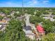 Aerial view of home nestled amongst mature trees in quiet neighborhood; clear skies above at 1209 E 29Th Ave, Tampa, FL 33605