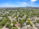 Aerial view shows neighborhood nestled amongst mature trees with skyline view of distant city at 1209 E 29Th Ave, Tampa, FL 33605