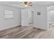 Bedroom showcasing modern floors, a ceiling fan, and a door to a bright, tiled bathroom at 1209 E 29Th Ave, Tampa, FL 33605