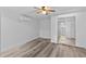 Spacious bedroom with modern wood-look floors, ceiling fan, AC unit and closet with mirrored sliding doors at 1209 E 29Th Ave, Tampa, FL 33605