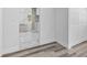 Hallway with grey floors, white marble floors, and white closet doors that leads to the kitchen at 1209 E 29Th Ave, Tampa, FL 33605