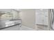 Well-lit kitchen featuring gray countertop, stainless steel faucet, and white marble-look flooring at 1209 E 29Th Ave, Tampa, FL 33605
