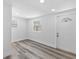 Brightly lit living room featuring grey floors, white walls, recessed lighting, and a white door at 1209 E 29Th Ave, Tampa, FL 33605