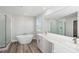 Bright bathroom featuring double vanity sinks, a soaking tub, and a glass-enclosed shower at 12156 Cattleside Dr, Riverview, FL 33579