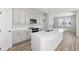 Contemporary kitchen with white cabinets, stainless steel appliances, and large island with a sink at 12156 Cattleside Dr, Riverview, FL 33579